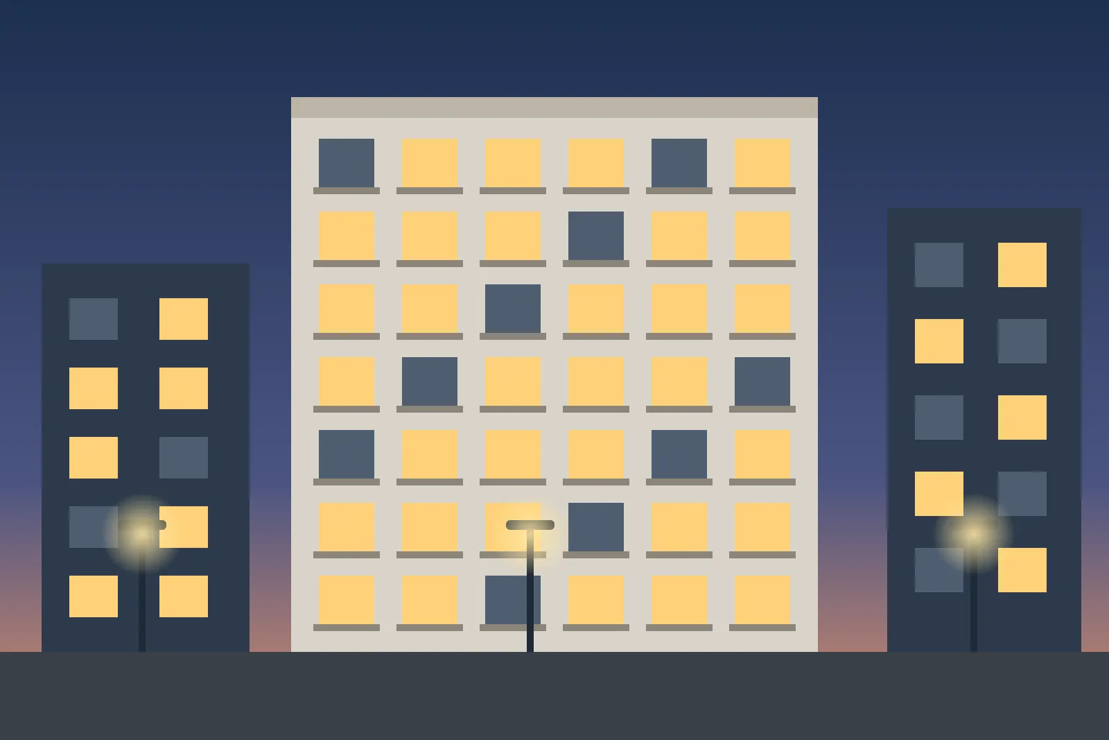 Block of city flats with lit windows and street lights in the evening