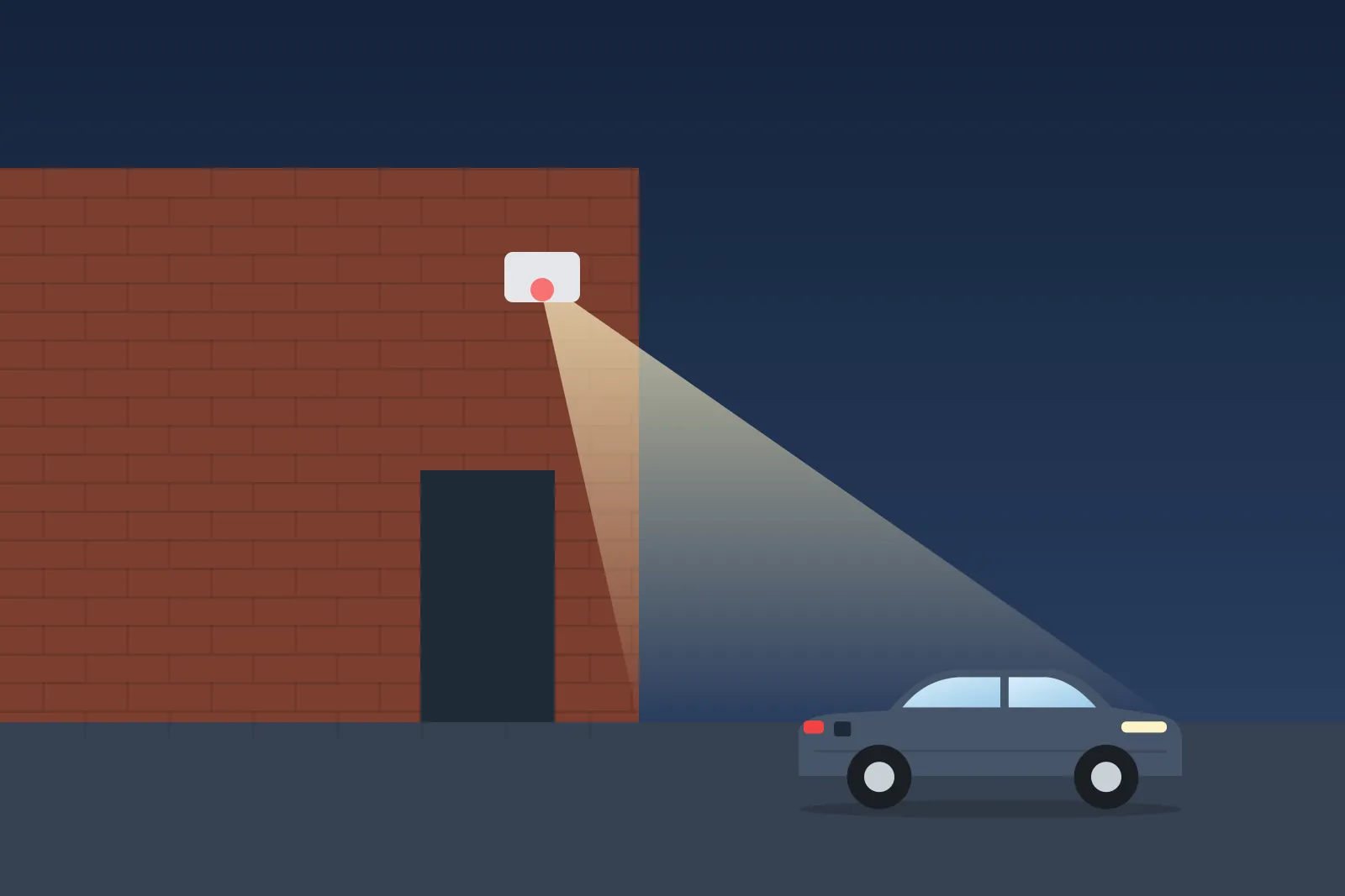 PIR security light on a brick house lighting up a driveway at night